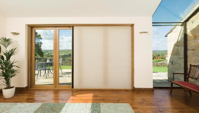 Centor oak bifold doors featuring a light-filtering shade for privacy and sun control