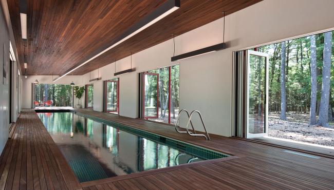 Centor integrated doors surrounding an indoor lap pool to allow a seamless connection to the forest outside