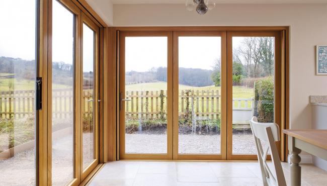 Two joining 205 Integrated Folding Doors with aligning panels overlooking farmland